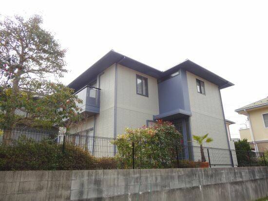 広島市安芸区矢野南F様邸 塗装後の側面 ベージュ系の外壁と濃紺のベランダ・玄関上の外壁