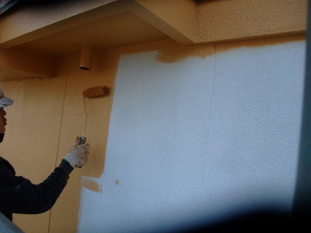 広島市安佐北区白木K様邸 白い下地の上にオレンジ系の色をローラーで塗り重ねている外壁