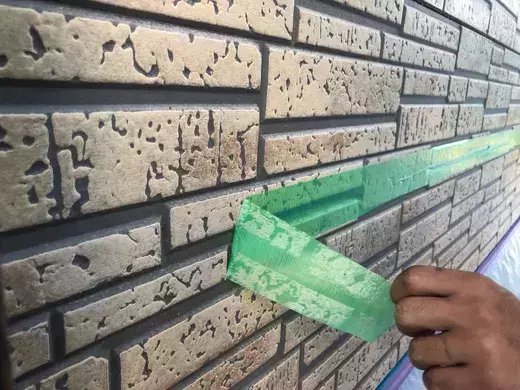廿日市市前空H様邸 施工前 劣化した塗膜をテープではがしているレンガ調の外壁