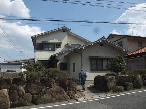 廿日市市大野丸石T様邸 外壁塗装前の外観全体（石垣の上に建つ2階建て）